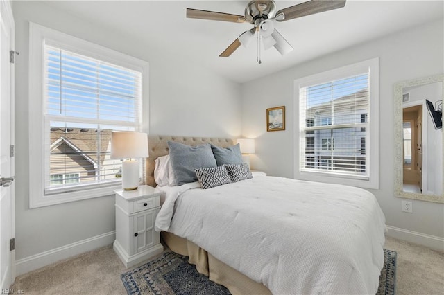 bedroom with baseboards, light carpet, and multiple windows