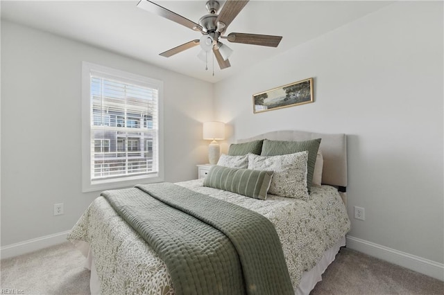 carpeted bedroom with ceiling fan and baseboards