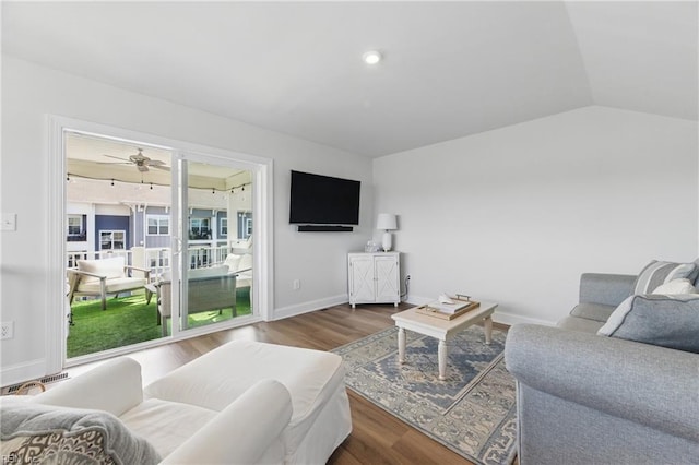 living room with baseboards, wood finished floors, ceiling fan, and lofted ceiling