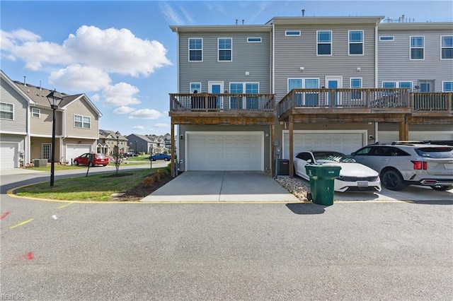 exterior space featuring a garage, central AC, a residential view, and concrete driveway