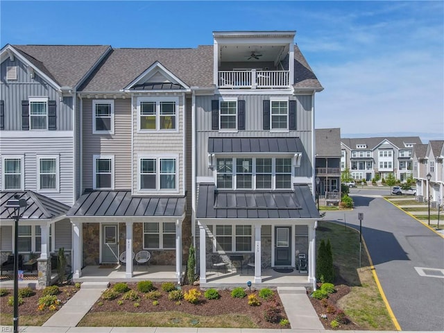 multi unit property featuring a standing seam roof, board and batten siding, a balcony, and stone siding