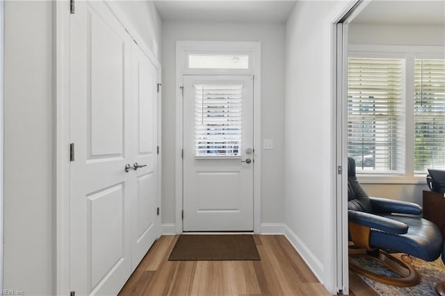 doorway to outside with wood finished floors and baseboards