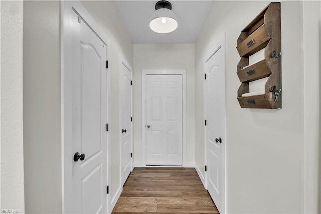 doorway to outside featuring wood finished floors and baseboards