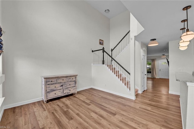 staircase featuring baseboards and wood finished floors
