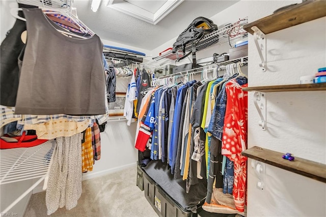 spacious closet with attic access and carpet flooring