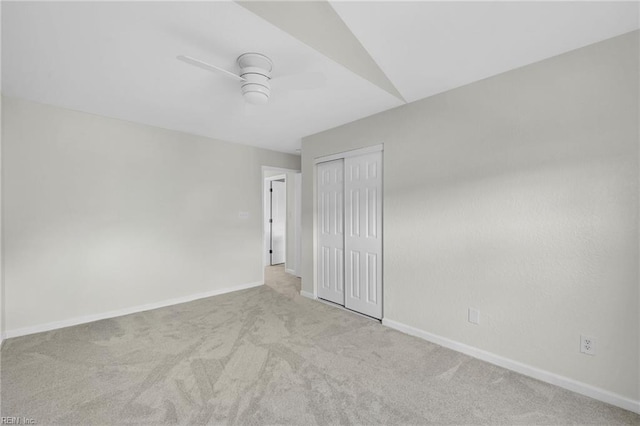 unfurnished bedroom featuring baseboards, carpet flooring, a closet, and ceiling fan