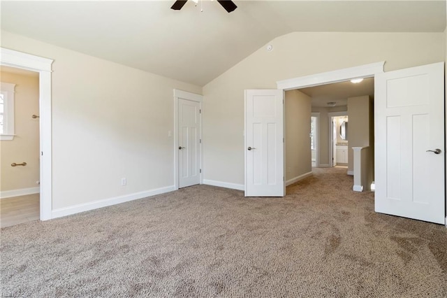 unfurnished bedroom with vaulted ceiling, baseboards, a ceiling fan, carpet floors, and connected bathroom