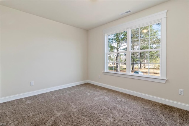 spare room with visible vents, baseboards, and a wealth of natural light