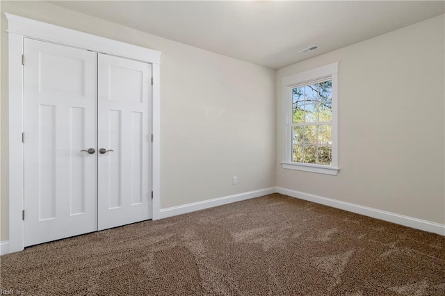 unfurnished bedroom with baseboards, a closet, visible vents, and carpet