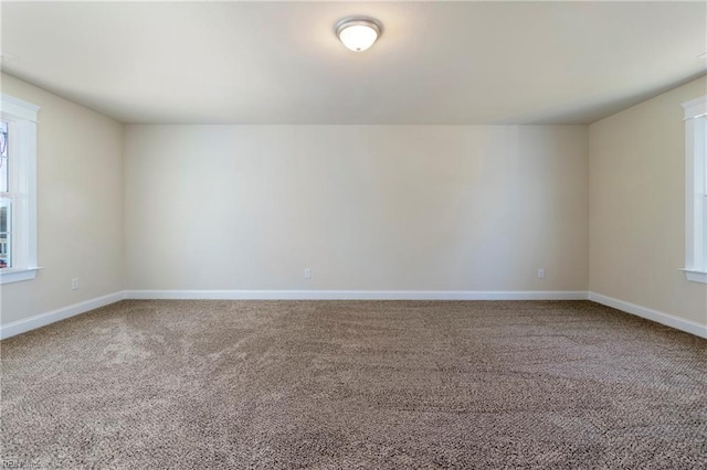 empty room featuring baseboards and carpet flooring