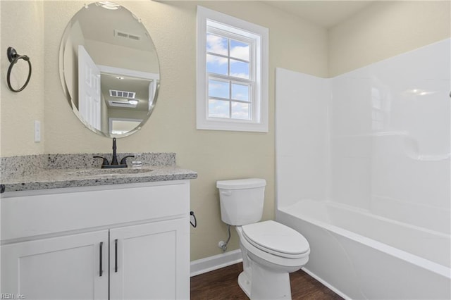 bathroom with wood finished floors, vanity, baseboards, toilet, and visible vents