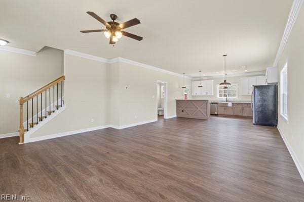 unfurnished living room featuring a ceiling fan, stairs, ornamental molding, and dark wood-style flooring