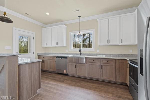 kitchen with crown molding, a healthy amount of sunlight, appliances with stainless steel finishes, and dark wood-style flooring