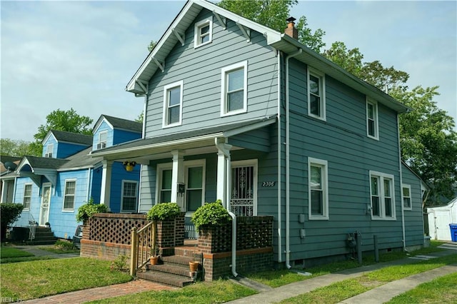 view of front facade with a chimney and a porch