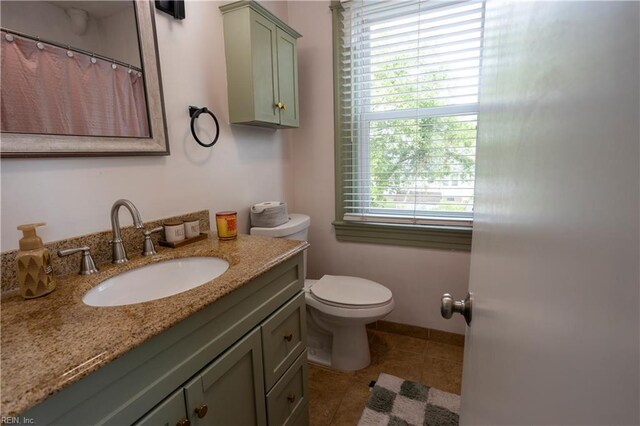 bathroom with a shower with curtain, vanity, tile patterned flooring, and toilet