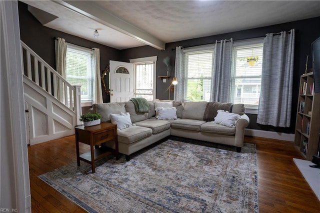 living room with stairs, beam ceiling, and dark wood-type flooring