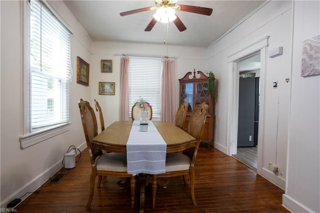 dining space with baseboards, a ceiling fan, wood finished floors, and visible vents
