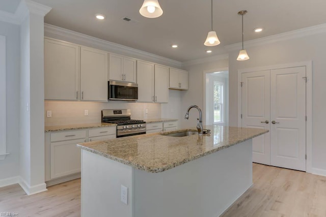 kitchen with light wood-type flooring, stainless steel appliances, a sink, and crown molding
