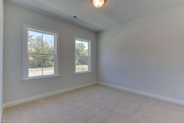unfurnished room with light colored carpet, baseboards, and visible vents