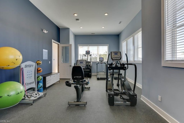 workout area featuring baseboards, a healthy amount of sunlight, and recessed lighting