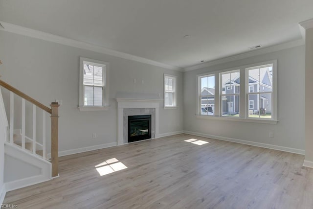 unfurnished living room with baseboards, wood finished floors, a fireplace, and crown molding