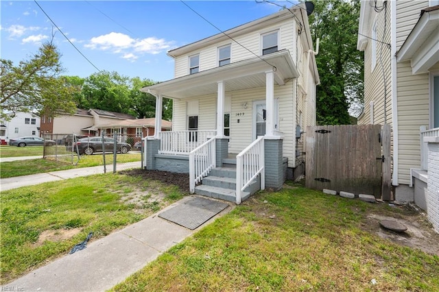 view of front facade featuring a front lawn, a gate, driveway, a porch, and fence