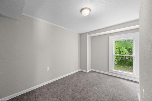 unfurnished room featuring a textured ceiling, carpet flooring, and baseboards