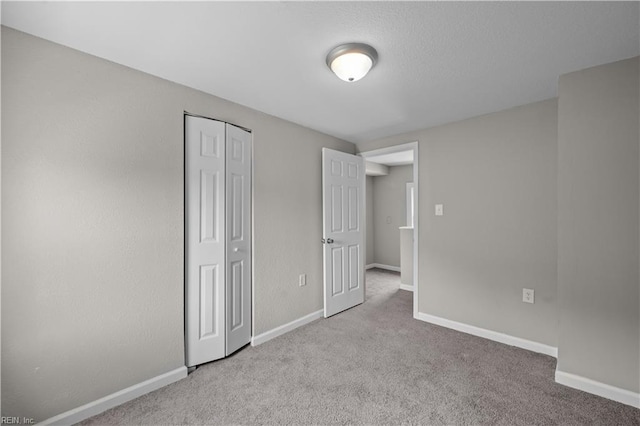 unfurnished bedroom with baseboards, a closet, and carpet
