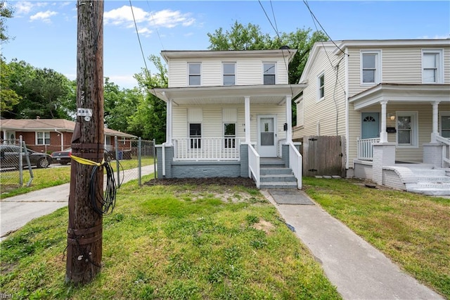 view of front facade with a porch, a front lawn, and fence