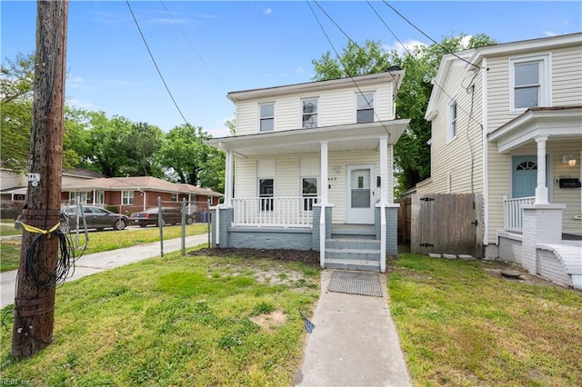 view of front of property featuring a front lawn, fence, and a porch