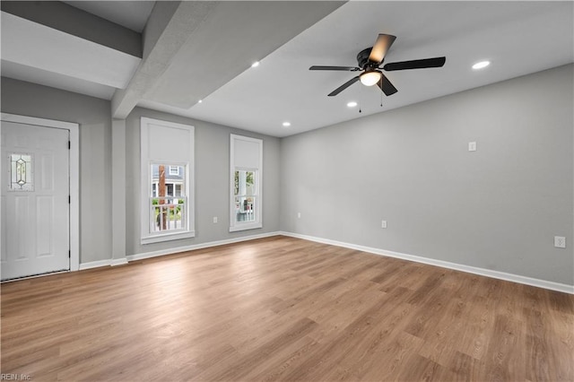 unfurnished living room with ceiling fan, beamed ceiling, light wood finished floors, baseboards, and recessed lighting