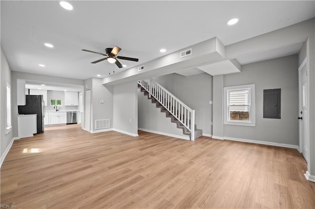unfurnished living room featuring recessed lighting, stairway, visible vents, and electric panel