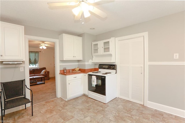 kitchen featuring a ceiling fan, electric stove, a textured ceiling, glass insert cabinets, and white cabinets