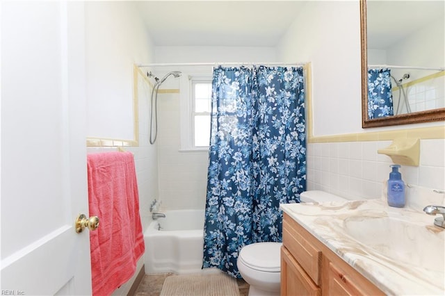 bathroom with shower / bath combo, toilet, tile walls, wainscoting, and vanity