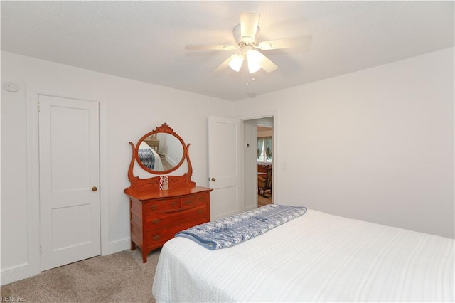 bedroom featuring light colored carpet and a ceiling fan