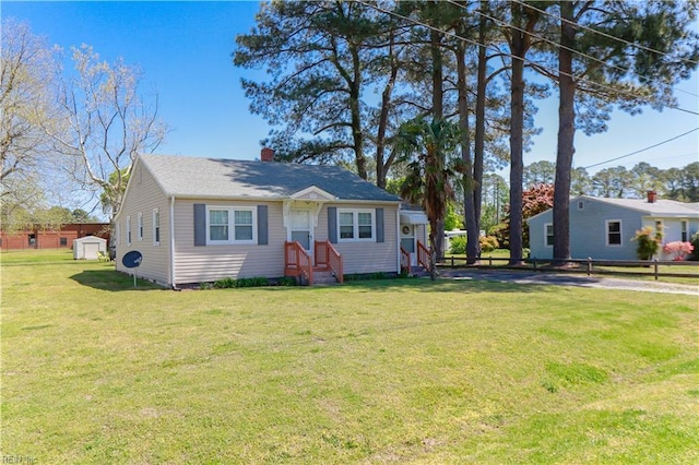 bungalow with a chimney, a front yard, and fence
