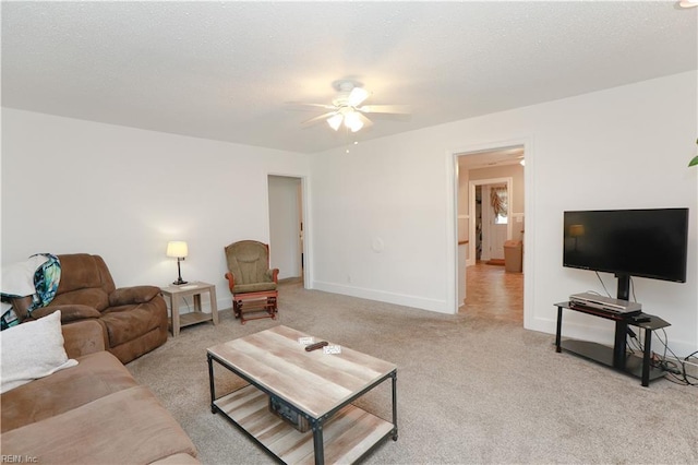 living area featuring carpet floors, a ceiling fan, and baseboards