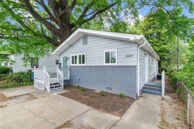 bungalow-style home featuring crawl space, brick siding, and a patio area