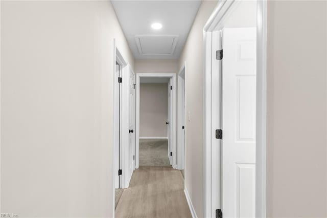 hallway featuring baseboards and light wood finished floors
