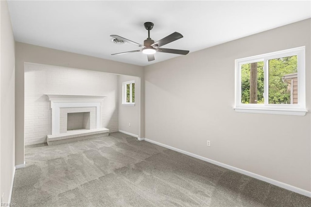 unfurnished living room featuring plenty of natural light, a ceiling fan, baseboards, and carpet floors