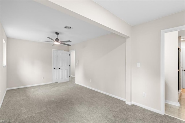 unfurnished room featuring baseboards, a ceiling fan, visible vents, and carpet floors