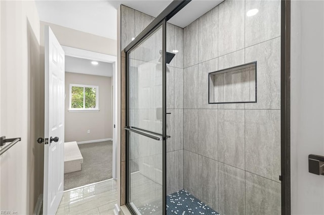 bathroom featuring a shower stall and baseboards