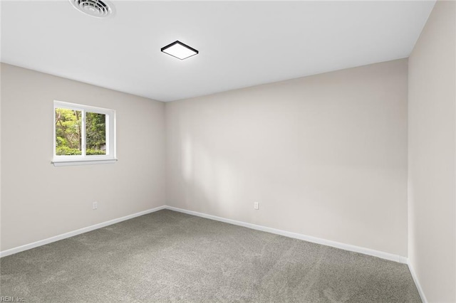 spare room featuring carpet floors, visible vents, and baseboards