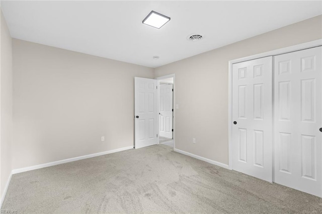 unfurnished bedroom with baseboards, a closet, visible vents, and carpet
