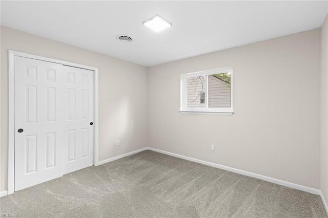 unfurnished bedroom with baseboards, carpet flooring, visible vents, and a closet