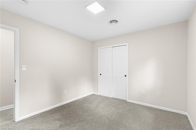 unfurnished bedroom with baseboards, a closet, visible vents, and carpet