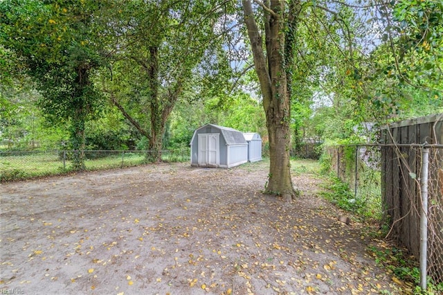 view of yard featuring fence, an outbuilding, and a storage shed