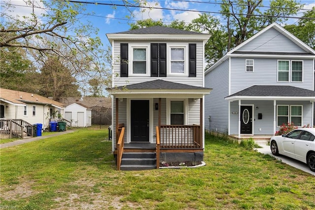 view of front of home with a storage shed, an outbuilding, covered porch, and a front yard