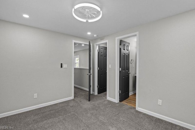 unfurnished bedroom with baseboards, carpet flooring, recessed lighting, and a walk in closet