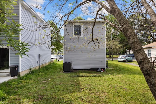 view of property exterior featuring central AC and a yard